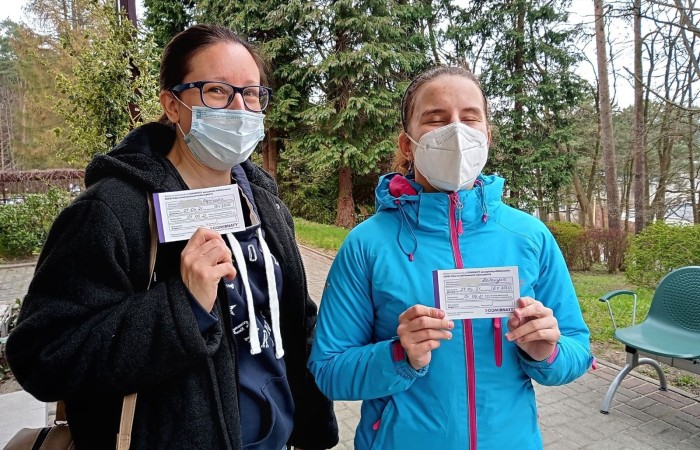 Dwie osoby na zdjęciu z dokumentem o szczepieniu