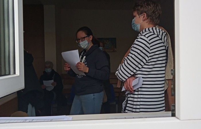 Dwie osoby w maseczkach w pomieszczeniu z otwartym oknem 