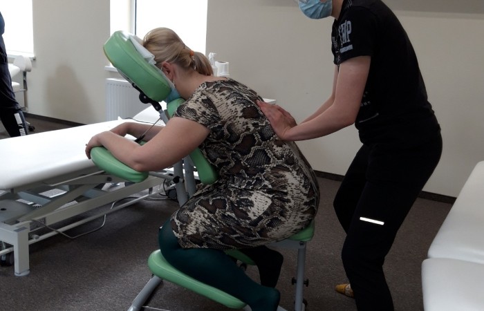 wykonywania masarzu osoby przez technika na krześle do masarzu 