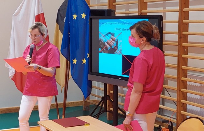 dwie panie w maseczkach omawiające prezentację