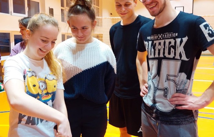 uczniowie krojący tort mikołajkowy na hali sportowej