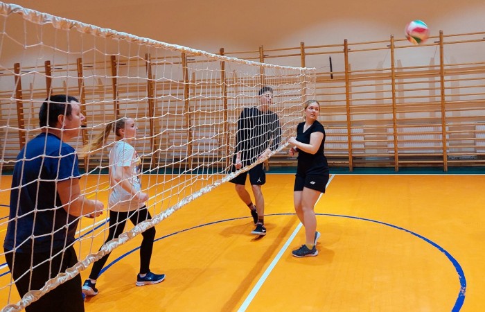 Uczniowie grający w siatkę na hali sportowej