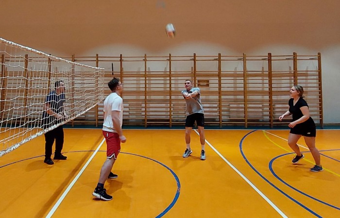 Uczniowie grający w siatkę na hali sportowej