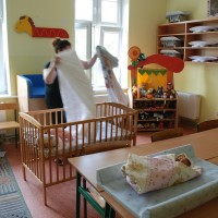 Pani układająca pościel w łóżeczku dziecięcym