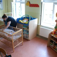 Pani układająca pościel w łóżeczku dziecięcym