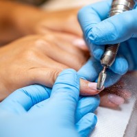 Uczennica wykonująca zabieg kosmetyczny rąk i paznokci