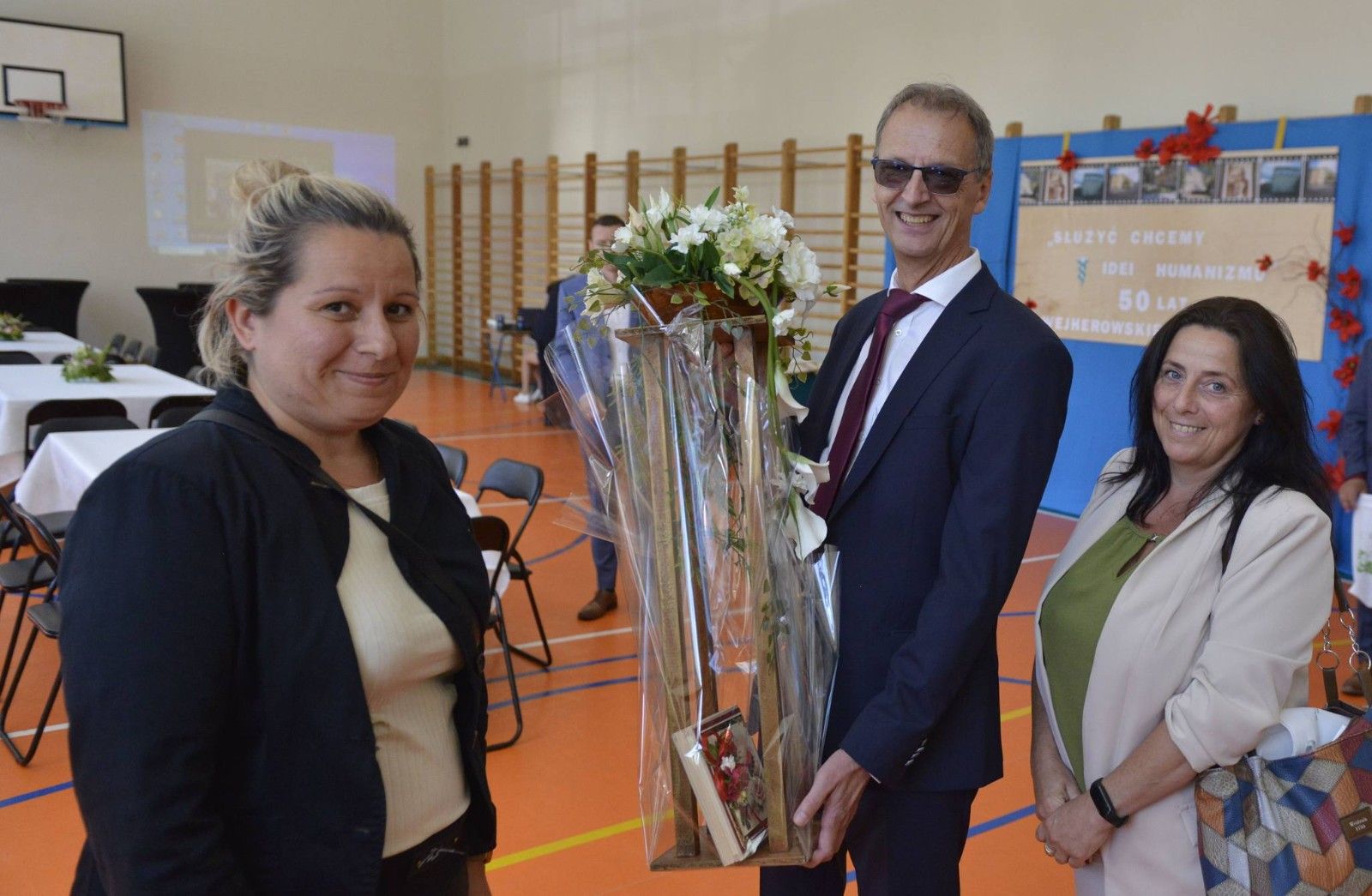 Dyrektor przyjmujący kwiaty od delegacji.