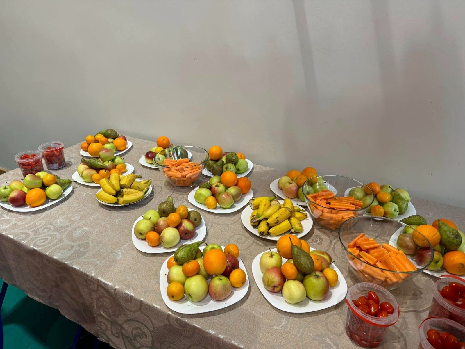 Widok na stół z talerzami wypełnionymi owocami.