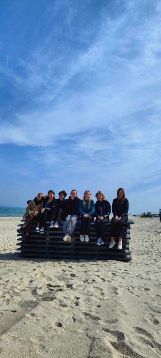 Grupowe zdjęcie uczniów na plaży nad morzem.