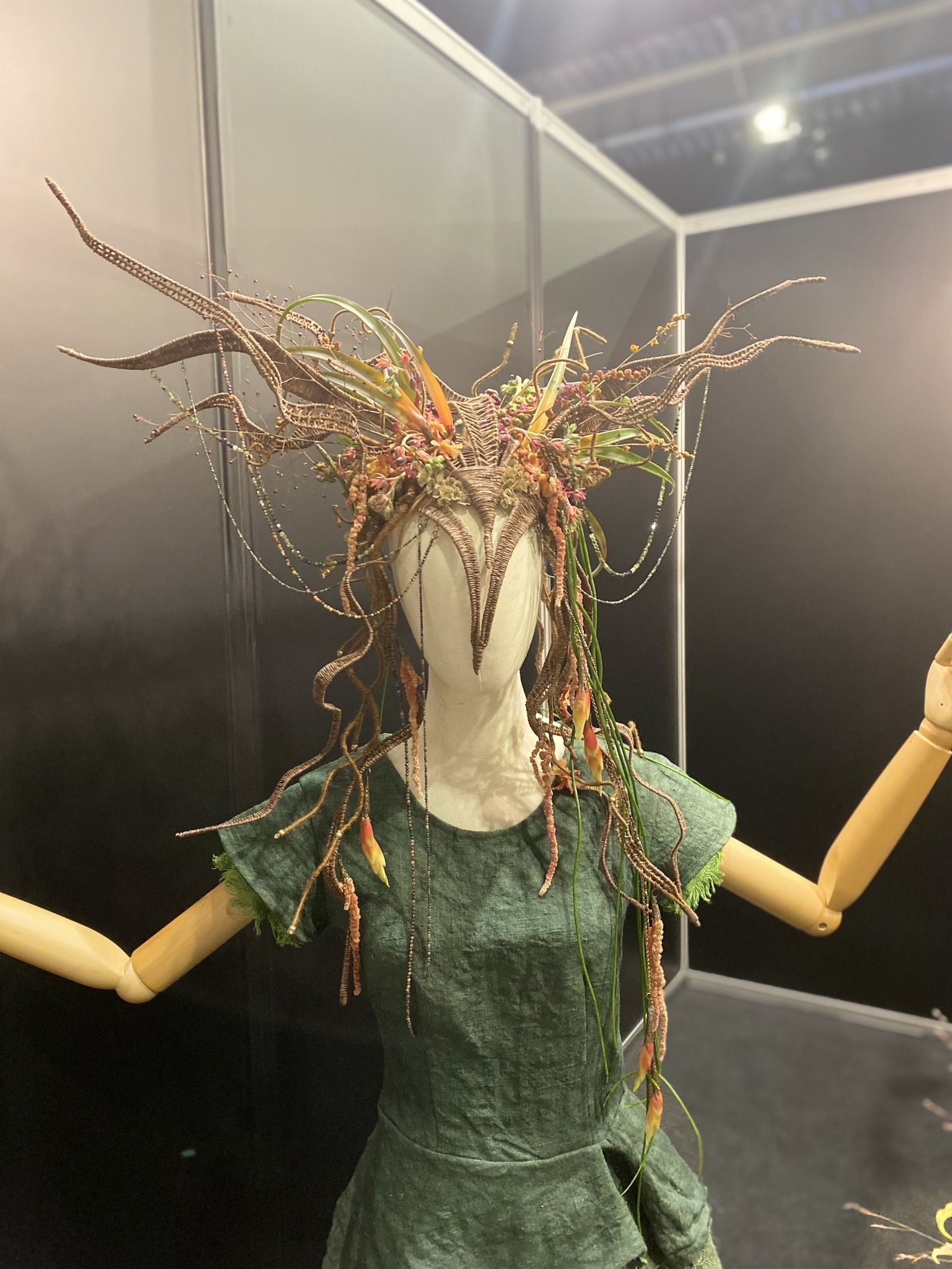 Kukła ubrana w ludowy strój z przystrojeniem głowy kwiatami.