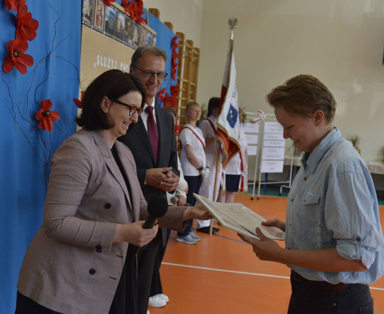Uczennica odbierająca świadectwo.