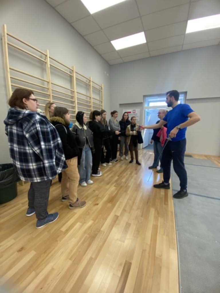 Grupa otrzymująca zalecenia na sali do fitness.