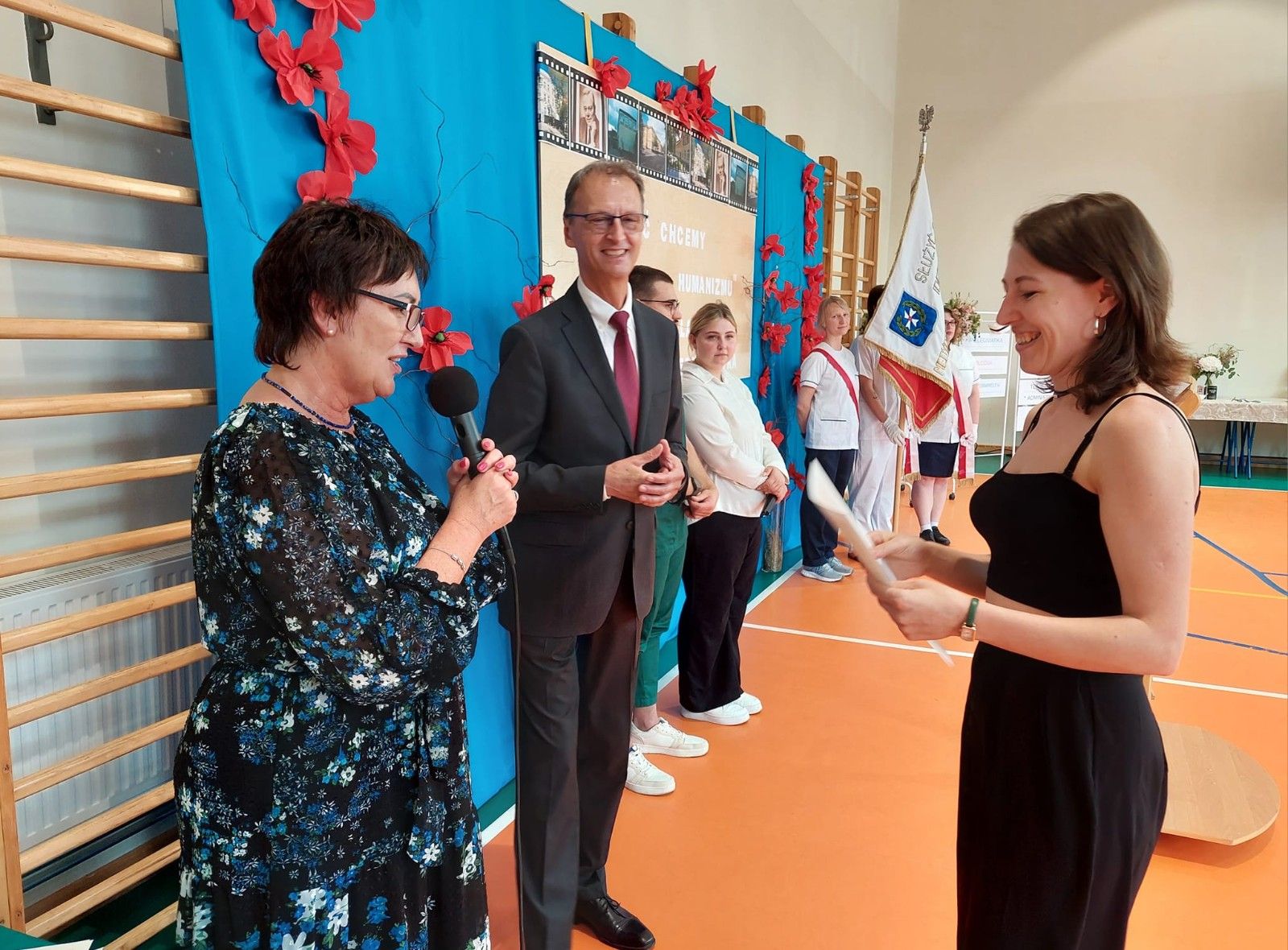 Zdjęcie Dyrekcji i ucznia odbierającego gratulacje.