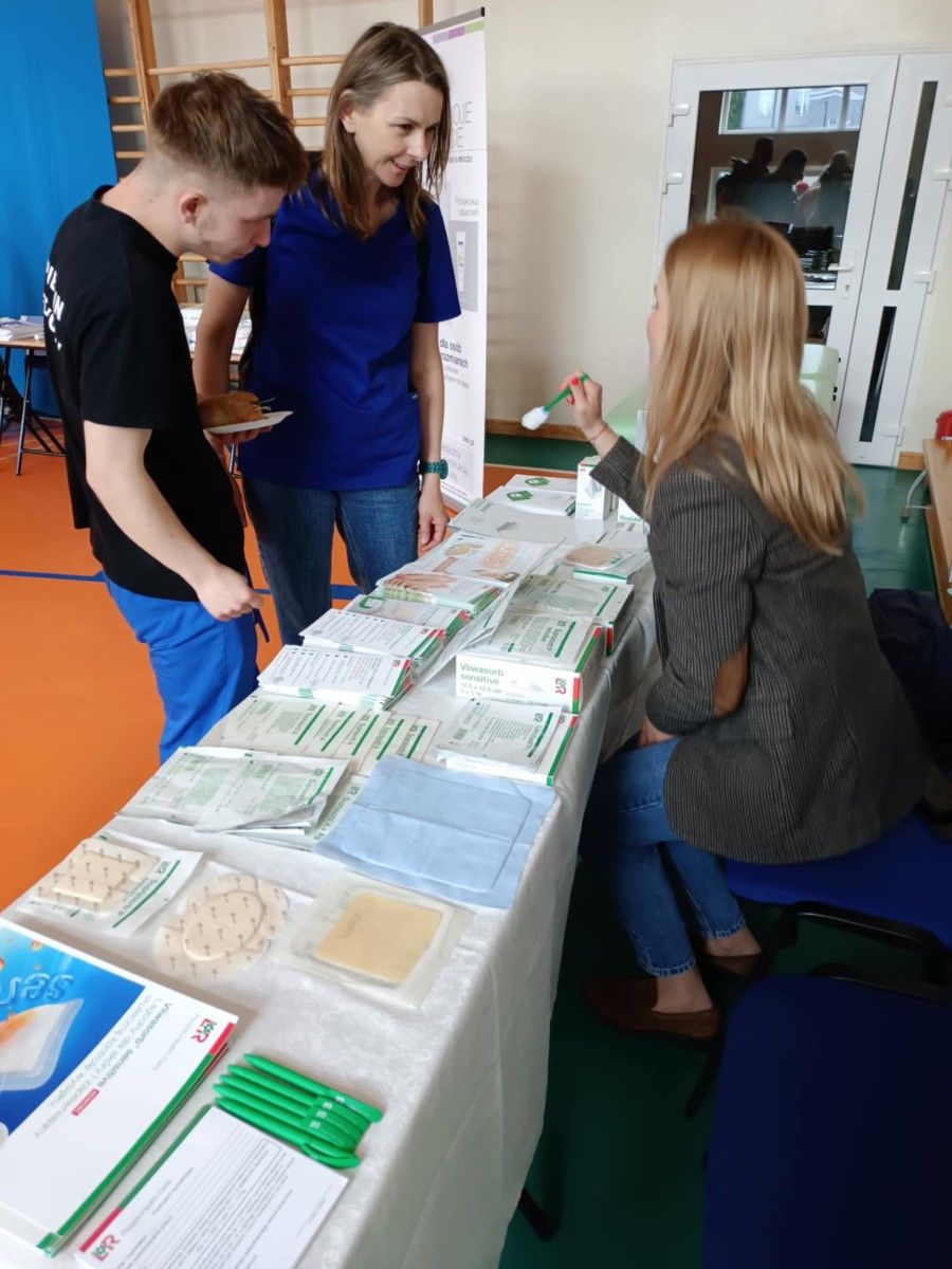 Widok na stół z ulotkami oraz akcesoriami warszatowymi.