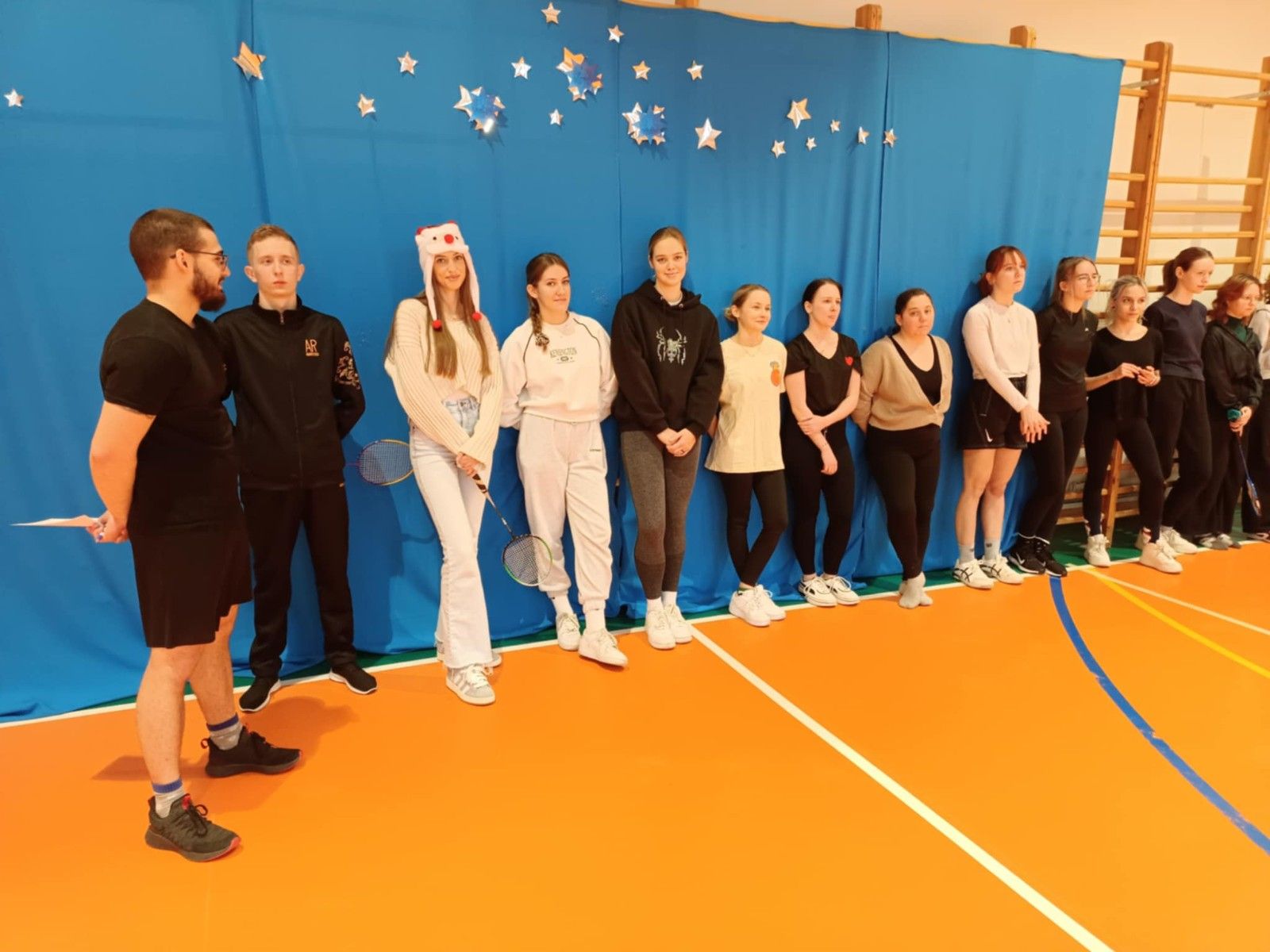 Widok na uczniów przygotowujących się do gry w badmintona.