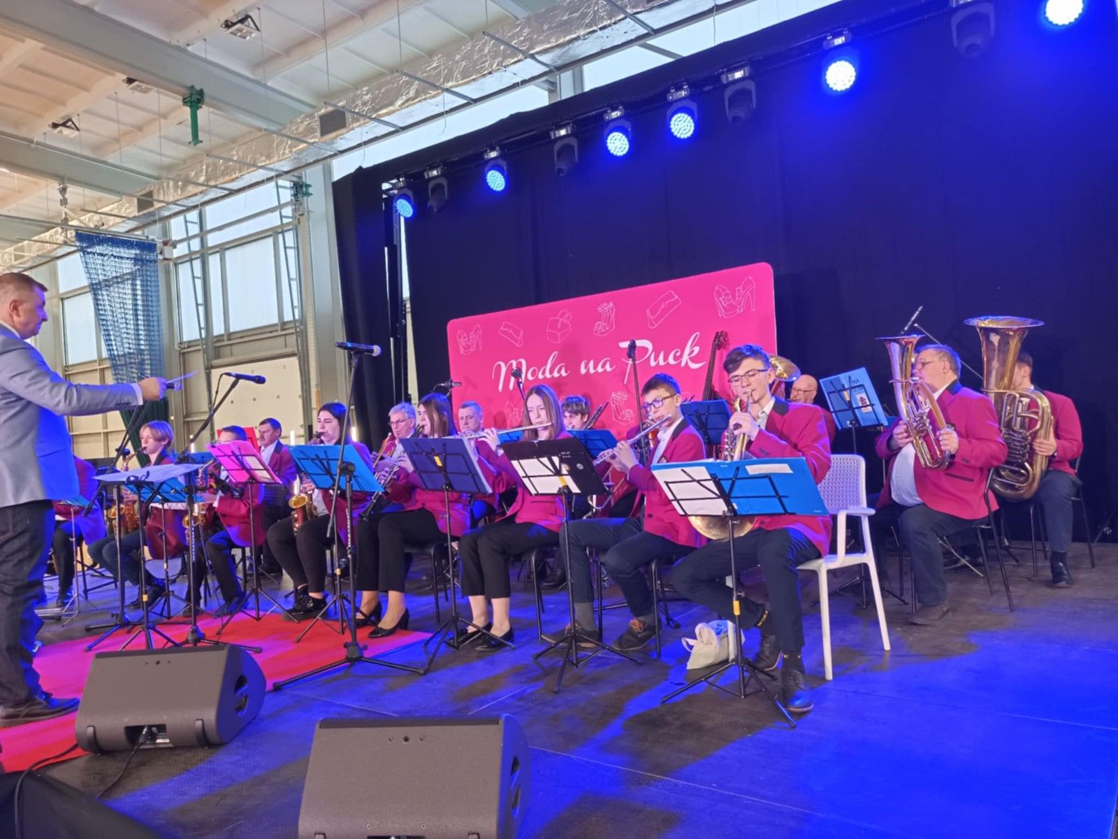 Widok na muzyków orkiestry dętej wykonujących utwór muzyczny.