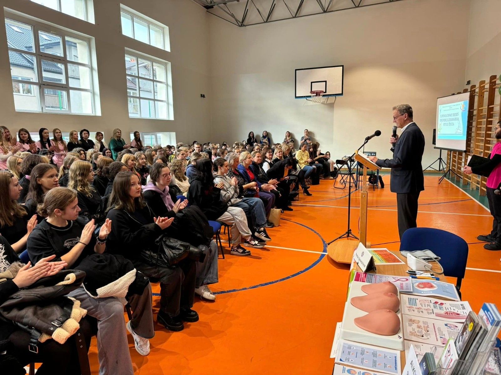 Widok na gości i przemawiającego Dyrektora Szkoły.