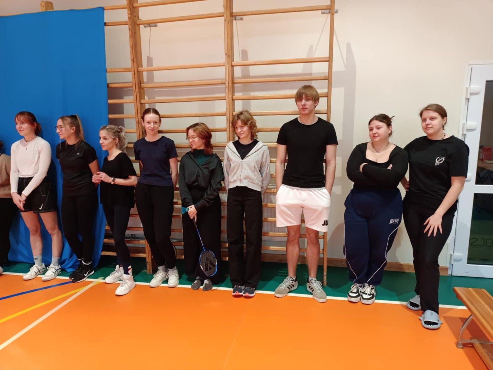 Widok na uczniów przygotowujących się do gry w badmintona.