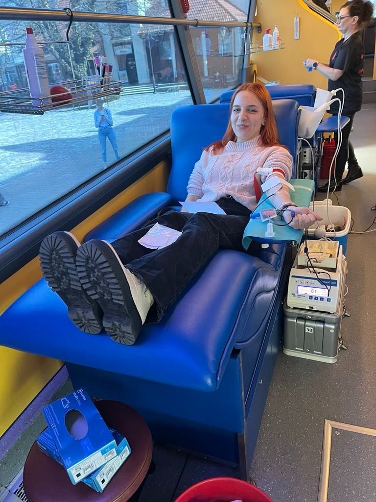 Kobieta oddająca krew w autobusie do mobilnej zbiórki krwi.