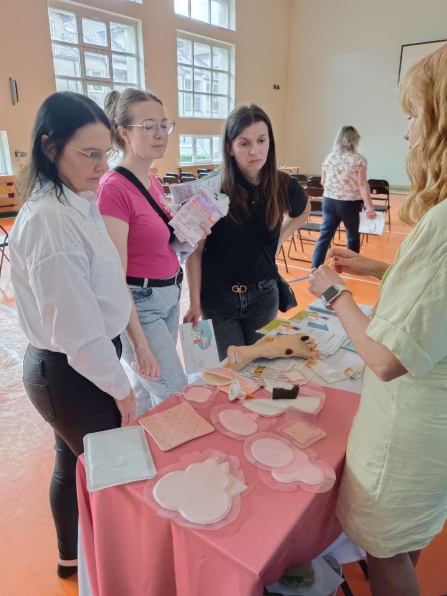 Uczestnicy warsztatów przy stole z akcesoriami zawodowymi.