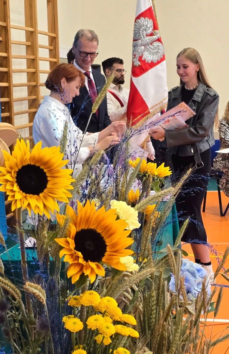 Zdjęcie nauczycieli Pana Dyrektora na tle z sztandarem szkoły.