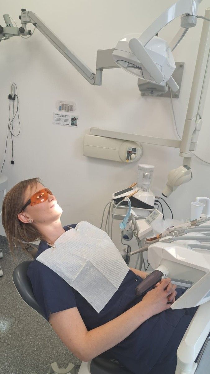 Uczestniczka badania stomatologicznego na krześle dentystycznym.
