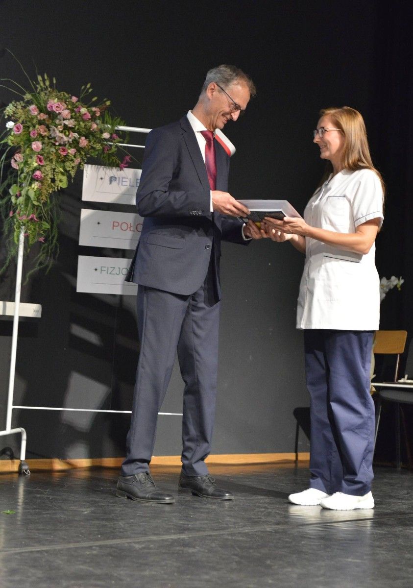 Dyrektor odbierający nagrodę na scenie.