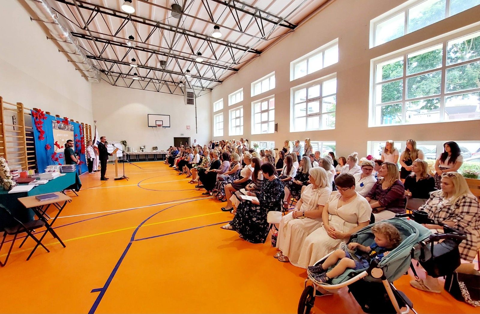 Zdjęcie hali sportowej podczas  trwania obchodów zakończenia roku szkolnego.
