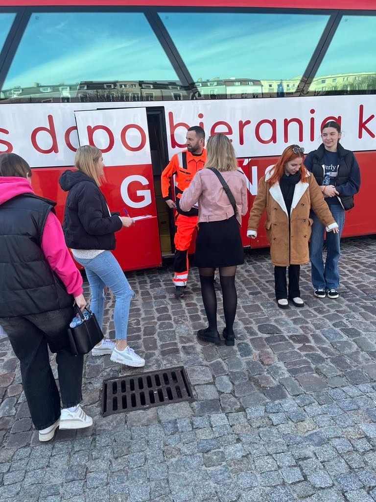 Widok na autobus do mobilnego pobierania krwi wraz z ratownikiem medycznym.