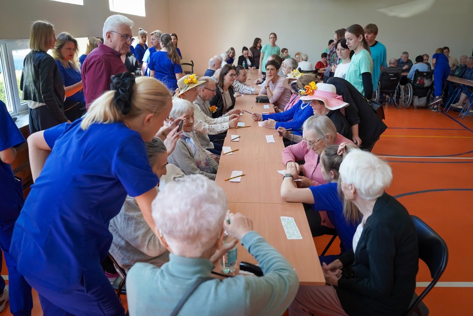 Widok na seniorów przy stole grających w bingo.