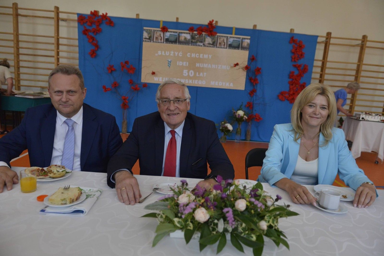 Zdjęcie trzech oficjalnych gości przy stole.