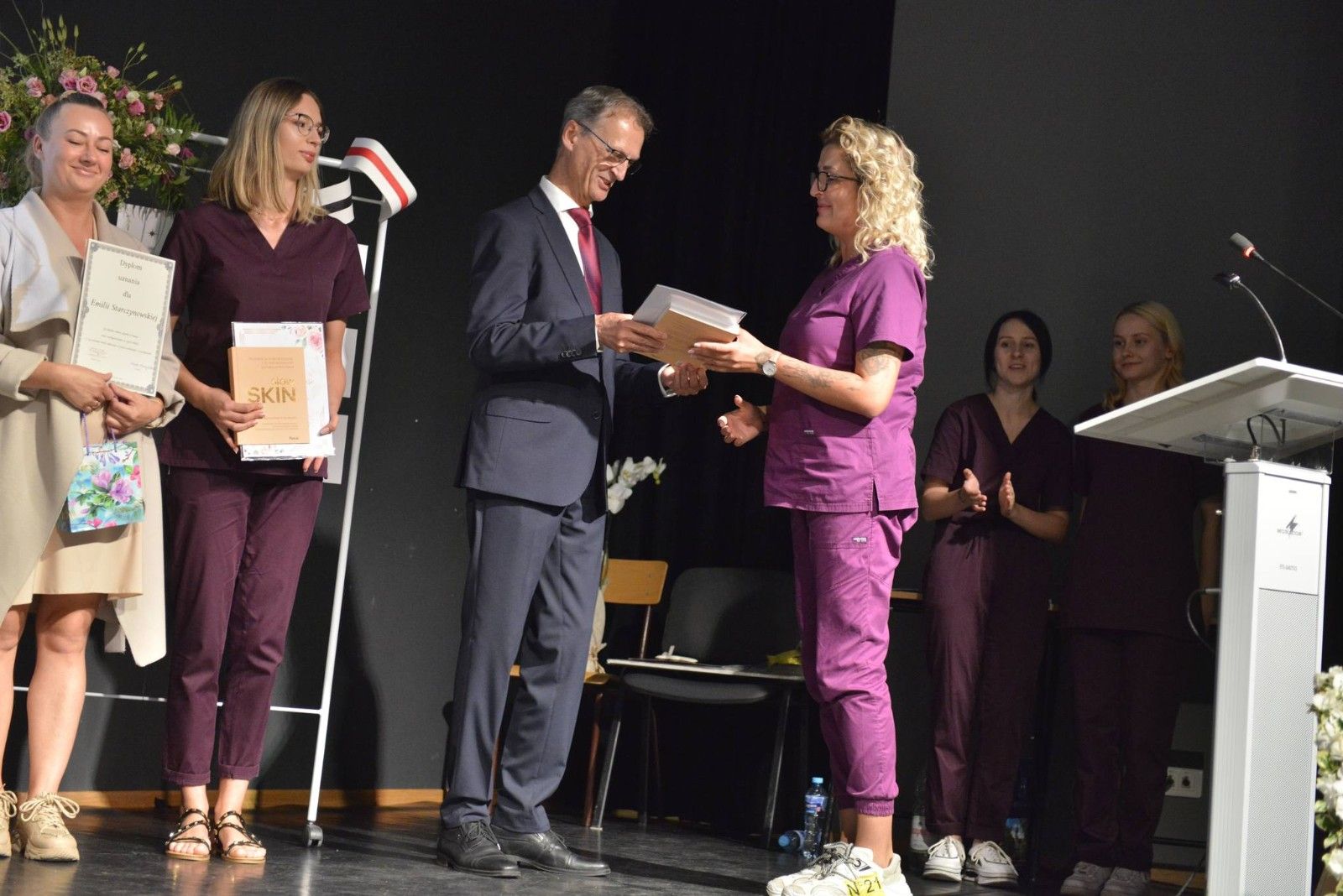 Dyrektor odbierający nagrodę i podziękowania.