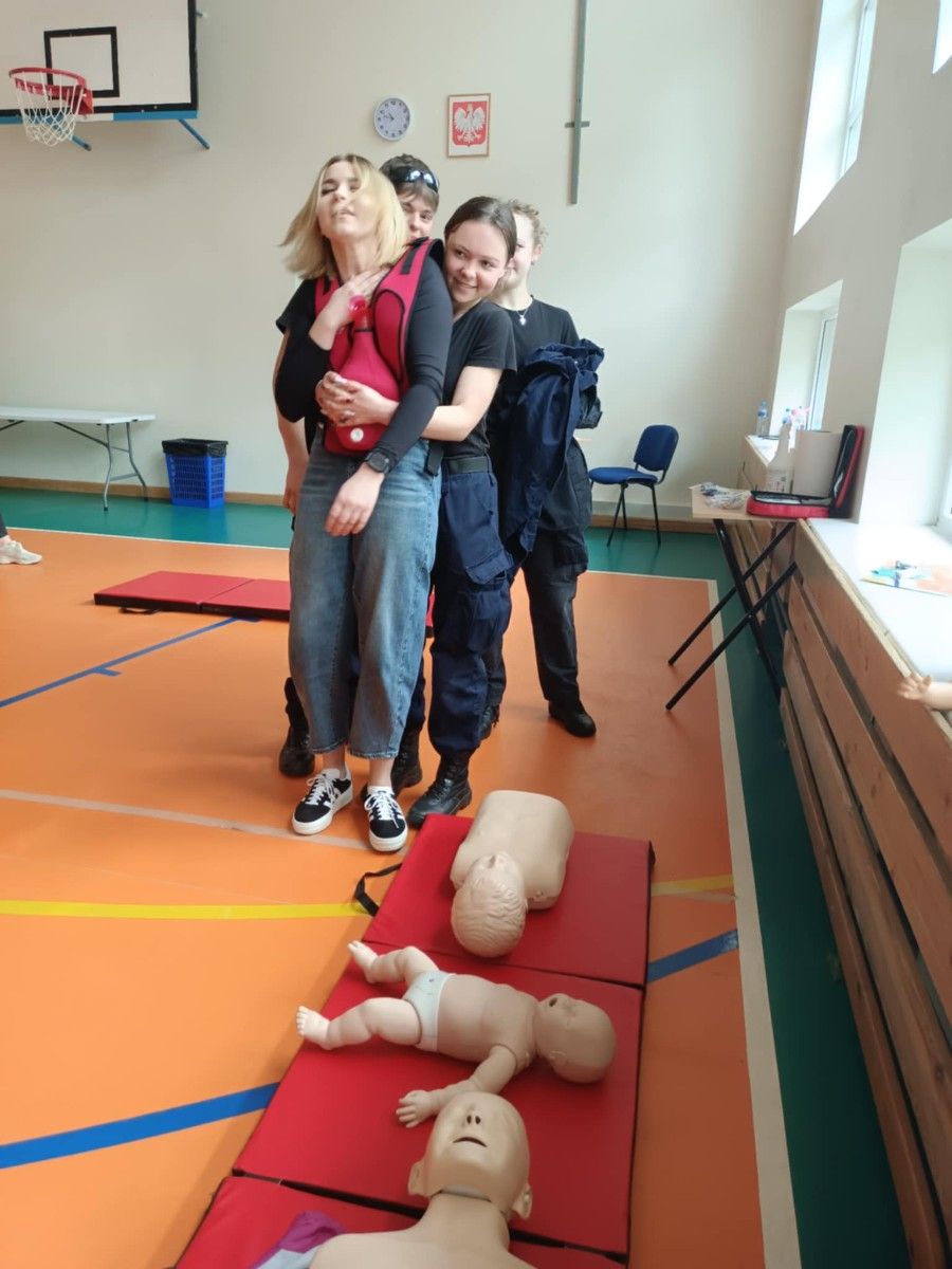 Uczestnicy gry ratujący zakrztuszona osobę.