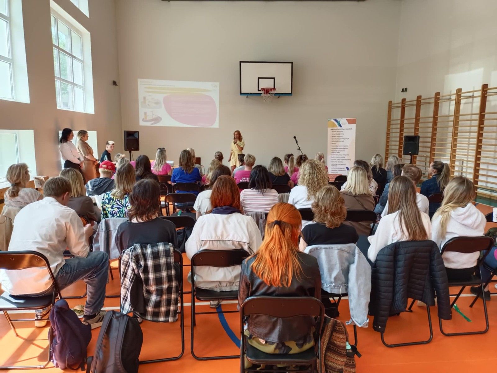 Widok na uczestników warsztatów oglądający prezentację na ekranie.