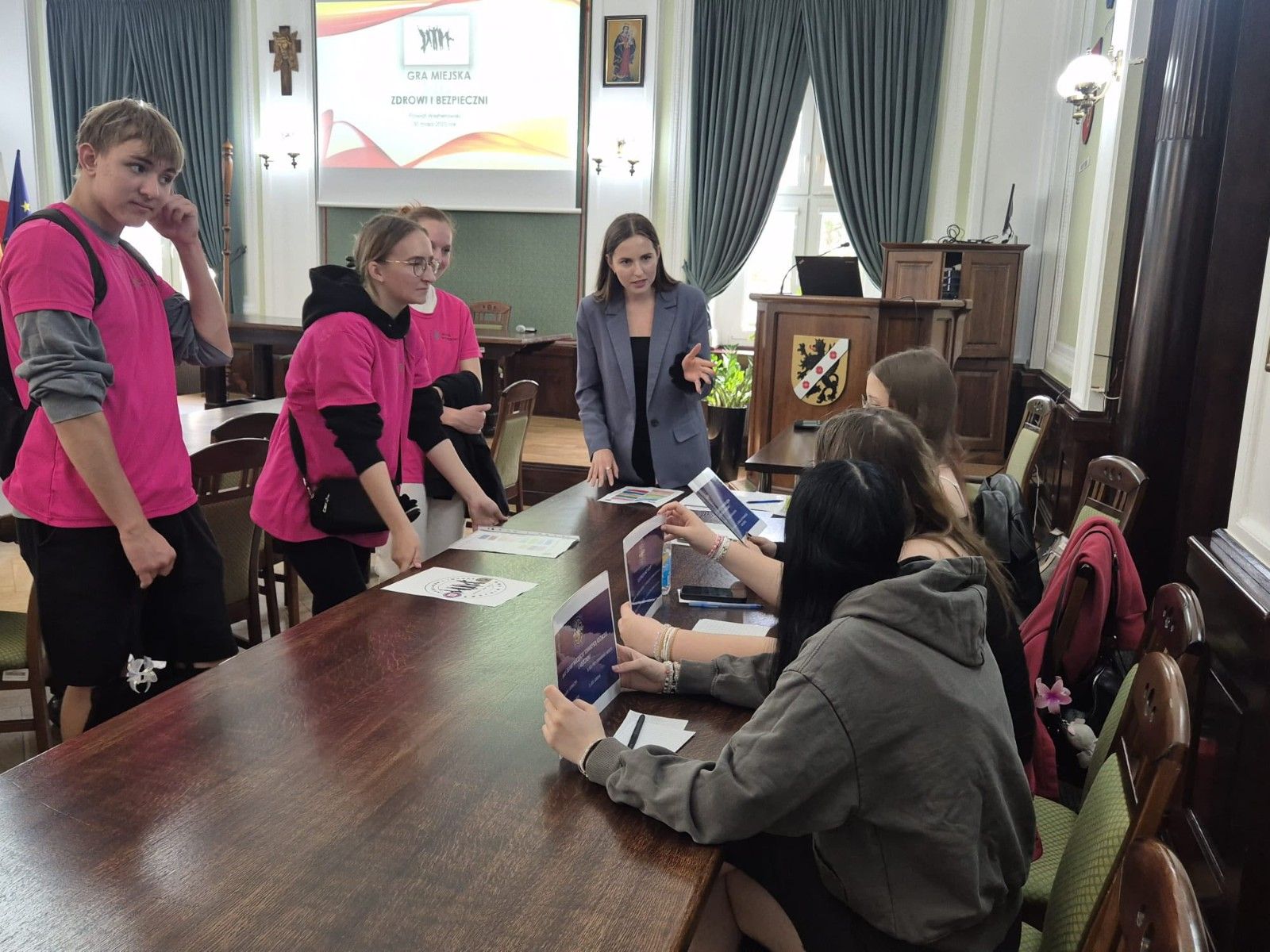 Zdjęcie uczestników przy stole w Starostwie podczas wykonywania zadnia.