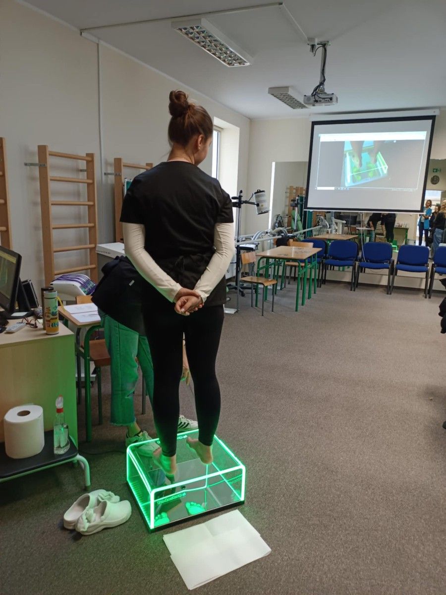 Uczeń poddający się badaniu pedologicznemu na specjalnym urządzeniu.