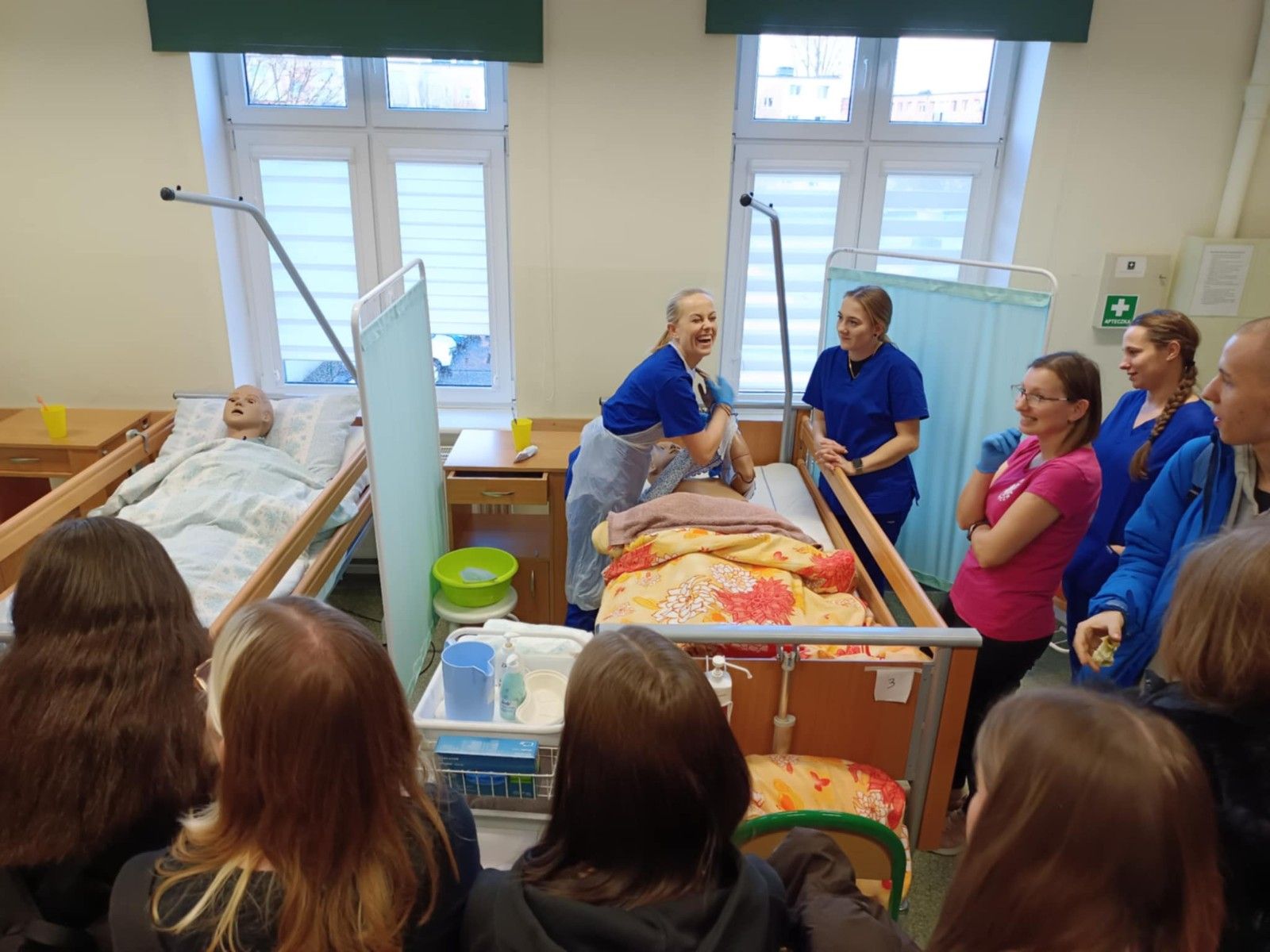 Uczniowie prezentujący pracę z chorym na manekinie w łóżku.