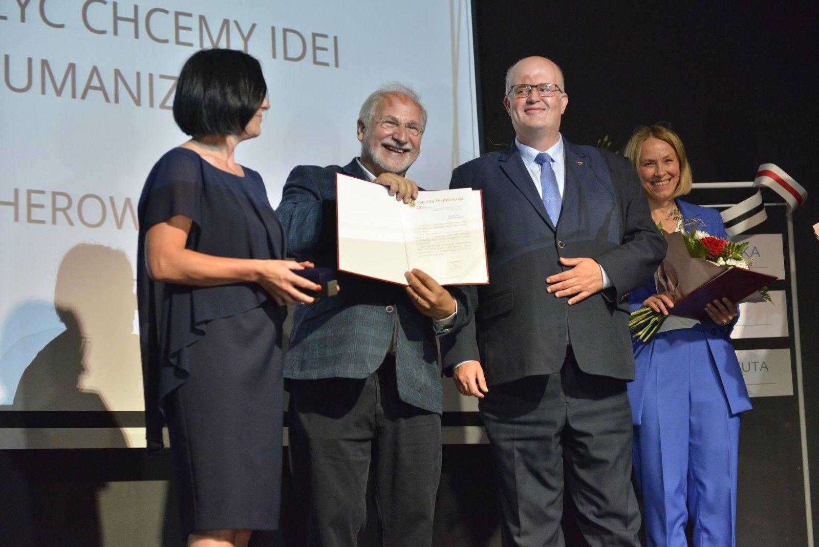 Nauczyciel szkoły odbierający nagrodę na scenie