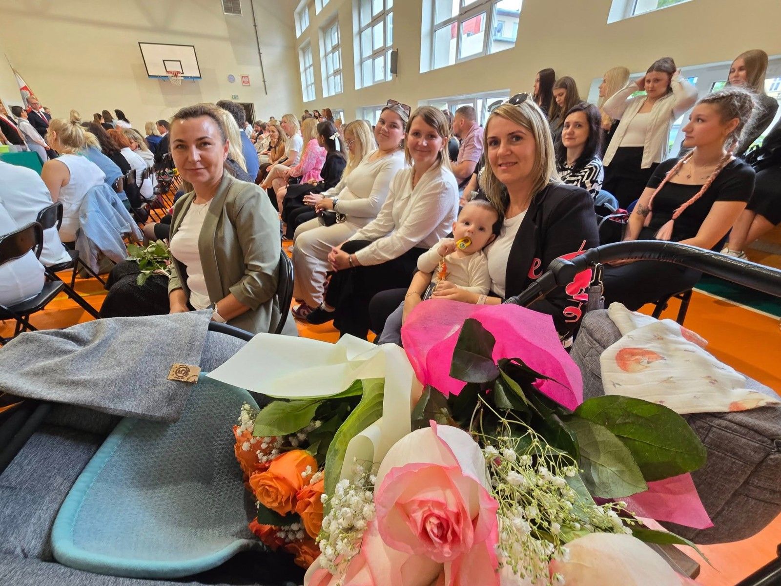 Zdjęcie uczestników zakończenia roku na hali sportowej.