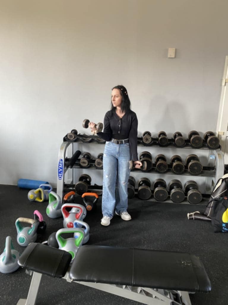 Uczennica wykonująca ćwiczenia hantlem.