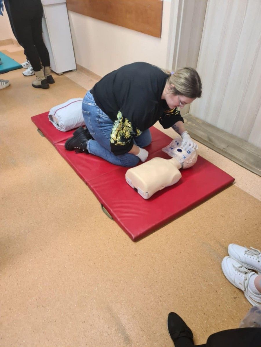 Uczennica wykonująca RKO na manekinie.