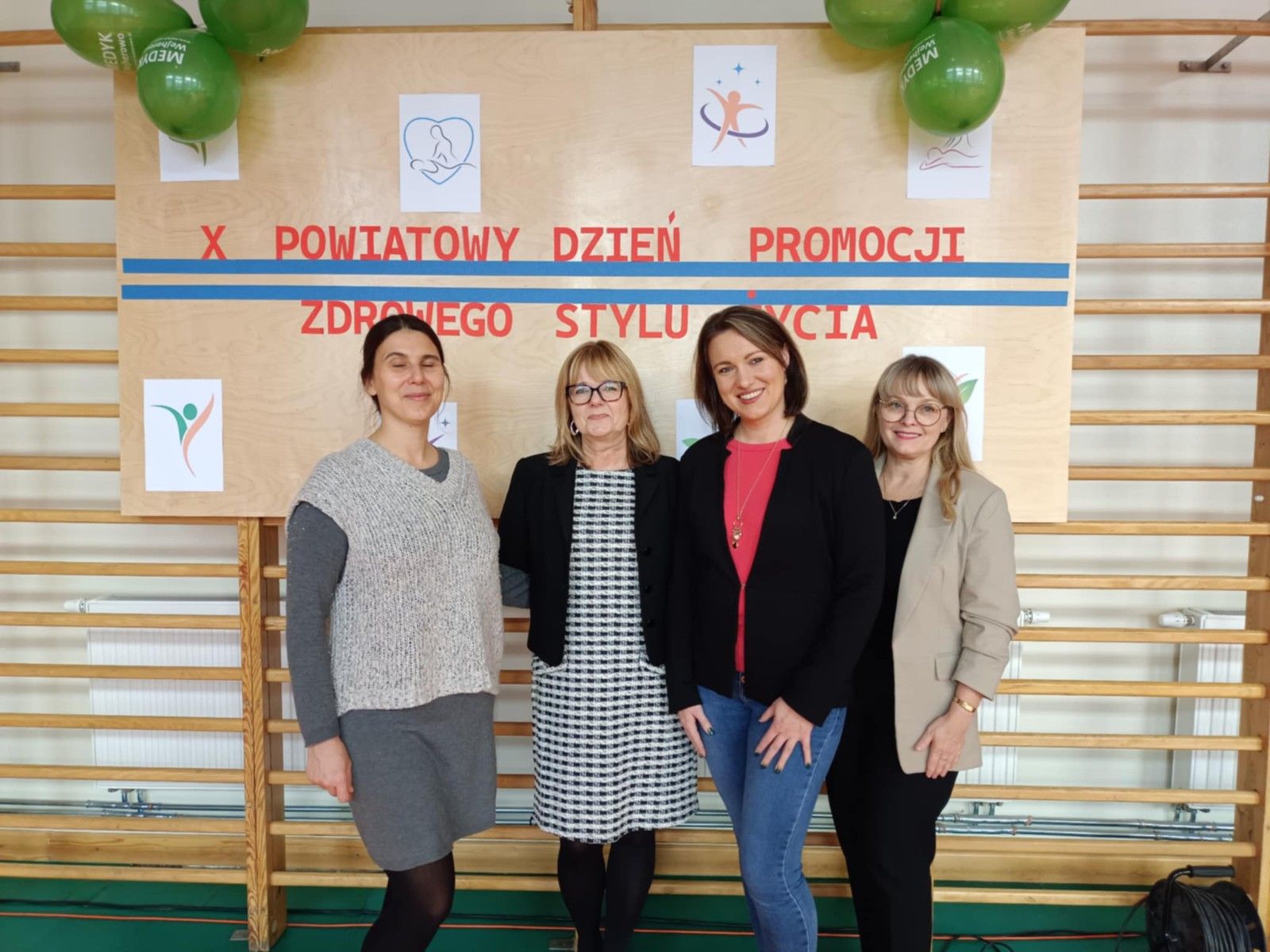 Wspólne zdjęcie nauczycieli i wykładowców na hali sportowej.