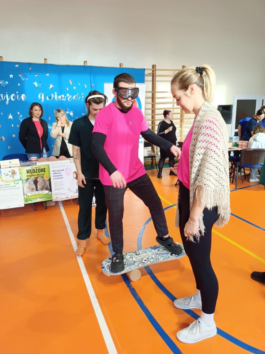 Uczeń wykonujący ćwiczenia na desce z rolką w okularach śnieżnych.