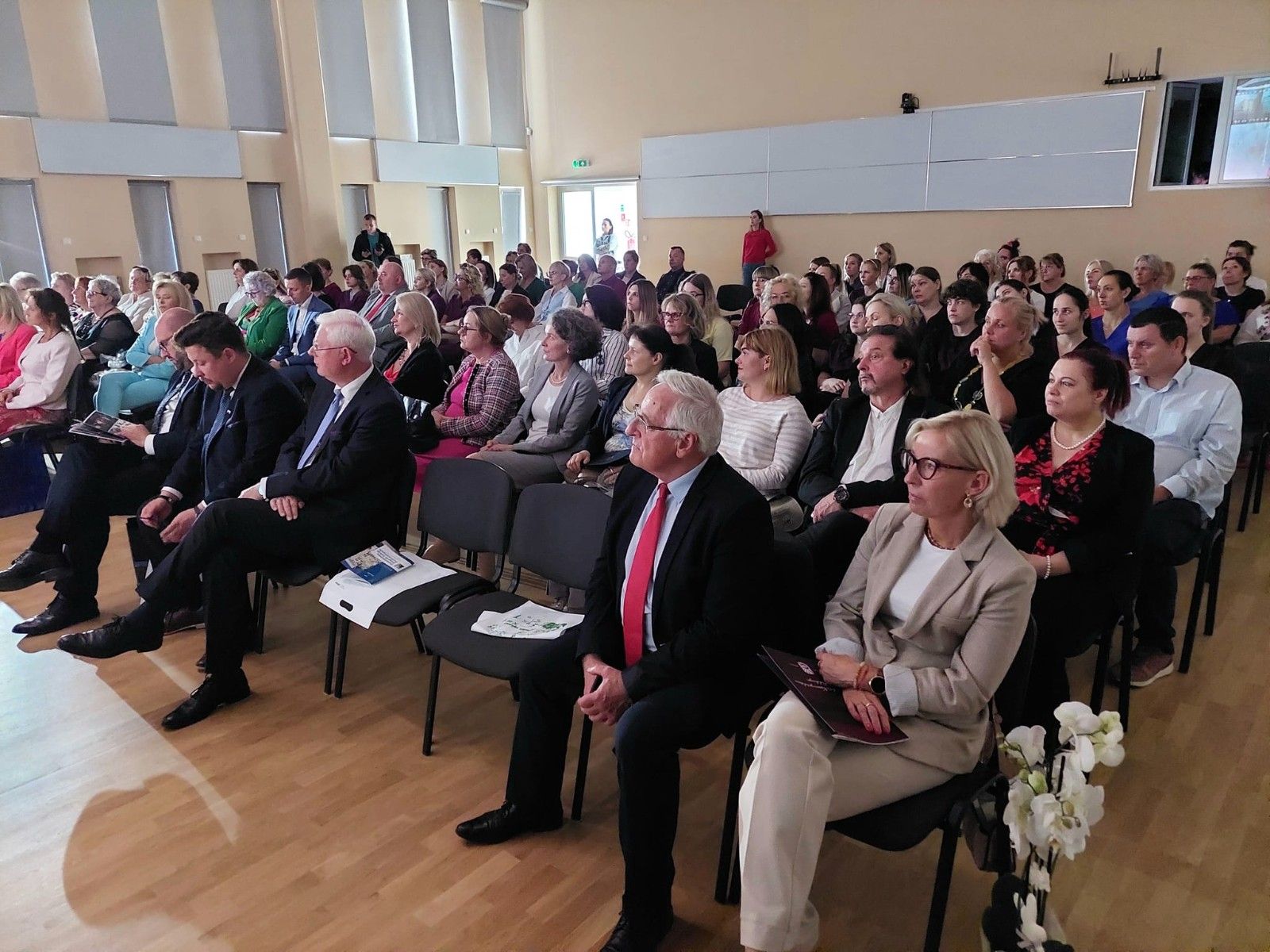 Goście siedzący w auli szkoły.