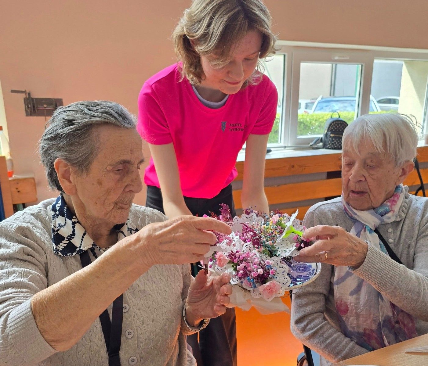 Seniorzy oceniający wykonane bukiety kwiatowe.