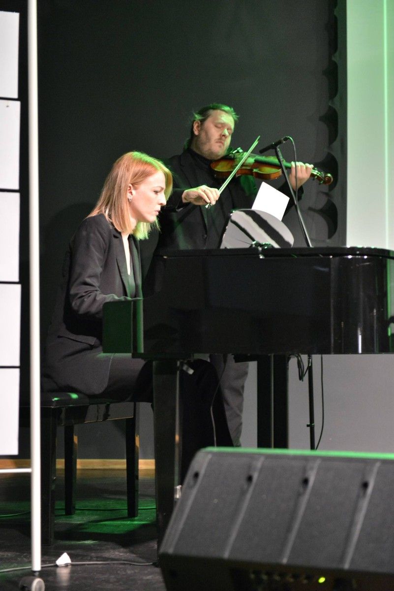 Muzycy grający  na skrzypcach i fortepianie.