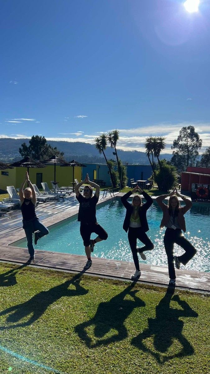 Dziewczyny wykonujące Jogę przed basenem w słońću.